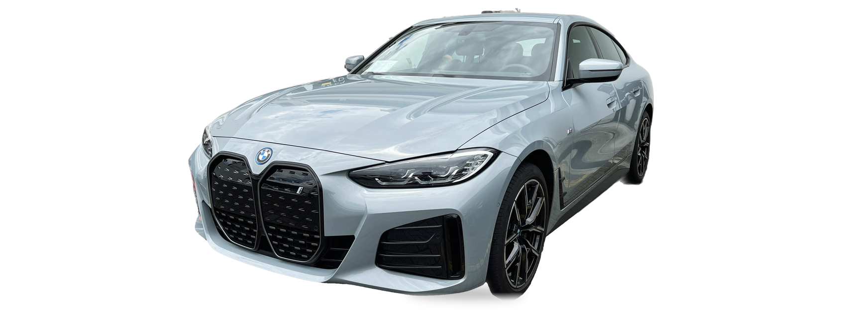 Light grey BMW i4 (G26) sedan, front three-quarter view, with the VIN locations marked